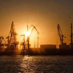 stock-photo-many-big-cranes-silhouette-in-the-port-at-golden-light-of-sunrise-reflected-in-water
